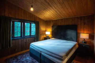 a bedroom with a large bed and two windows at Trysilfjellet Nord 170 in Trysil