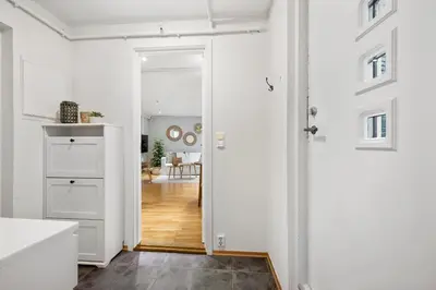 a kitchen with white walls and a door leading to a living room at Charming apartment 200m from Bryggen in Bergen