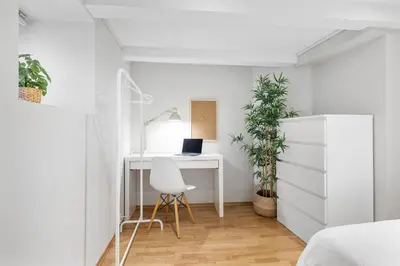 a bedroom with a desk with a laptop on it at Charming apartment 200m from Bryggen in Bergen