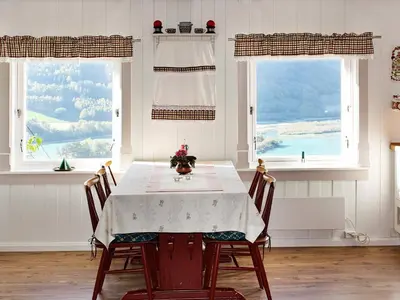 a dining room with a table and two windows at 6 person holiday home in Otta in Otta