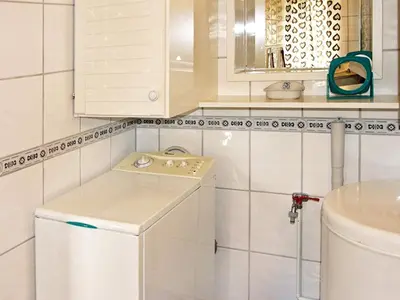 a bathroom with a washing machine and a sink at 6 person holiday home in Otta in Otta