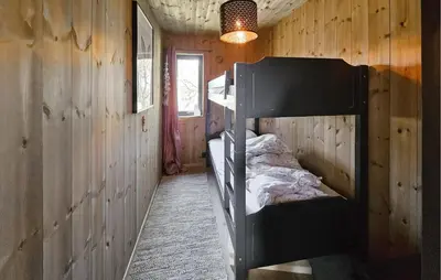 a bedroom with two bunk beds in a wooden wall at Cozy Home In Rauland With Sauna in Rauland