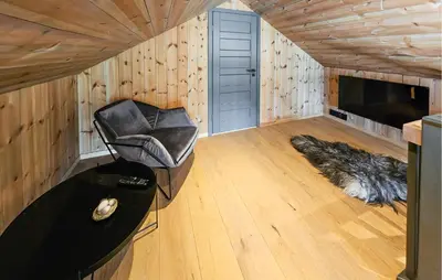 a living room with a leather chair and a table at Cozy Home In Rauland With Sauna in Rauland