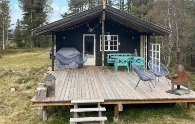 a cabin with a table and chairs on a deck at Cozy Home In Vinje With Wifi in Hommo