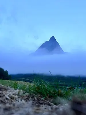 a mountain in the fog with a hill in the background at Hybelleilighet 4 pers ski-VM 2025 in Trondheim