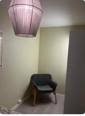 a room with a chair and a light fixture at Unik og koselig leilighet midt i sentrum av Trondheim in Trondheim