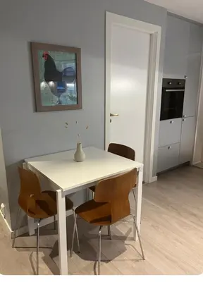 a white dining room table with chairs and a vase on it at Unik og koselig leilighet midt i sentrum av Trondheim in Trondheim