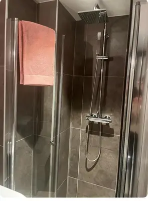 a bathroom with a shower with a glass door at Unik og koselig leilighet midt i sentrum av Trondheim in Trondheim