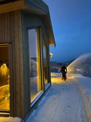a person is standing next to a building in the snow at Ny koselig hytte ved Sogn skisenter in Hafslo
