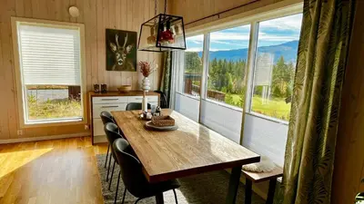 a dining room with a table and some windows at Modern cabin, great view, sunny, 2BA, 4BR in Hemsedal