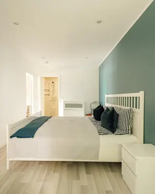 a bedroom with a large white bed with pillows at Vestre apartment in Ålesund