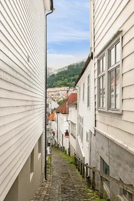 an alley between two buildings in a town at 500 m til Bryggen I Skjermet Uteplass! in Bergen