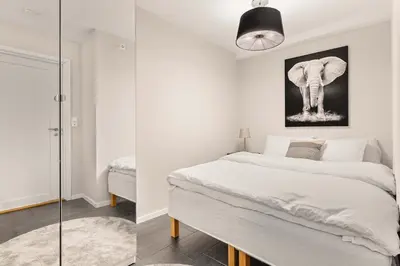 two images of a bedroom with a bed and an elephant at 500 m til Bryggen I Skjermet Uteplass! in Bergen