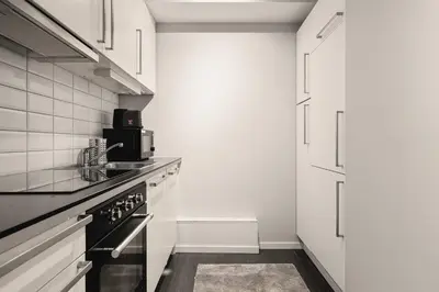 a kitchen with a sink and a stove at 500 m til Bryggen I Skjermet Uteplass! in Bergen