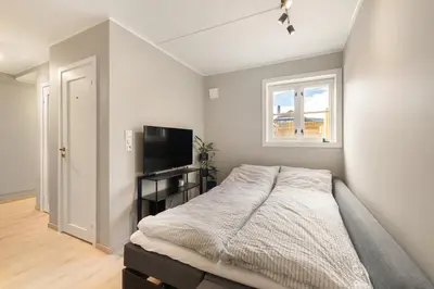 a bedroom with a bed and a flat screen tv at Central and modern apartment in Trondheim
