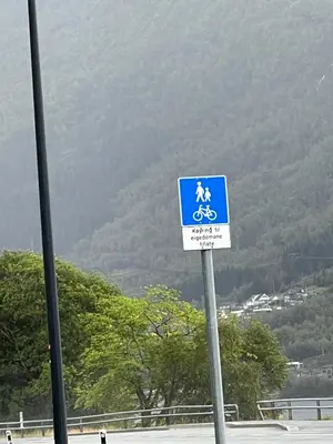 a blue and white sign with a person riding a bike at Husslåttene apartments with terrace in Skei
