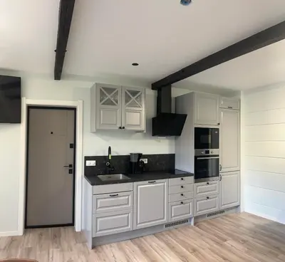 a kitchen with white cabinets and black counter tops at Husslåttene apartments with terrace in Skei