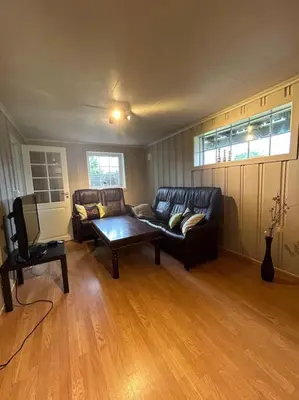 a living room with a couch and a tv at Sokkel-leilighet med nærhet til sentrum og Hovden skiheis in Oppdal