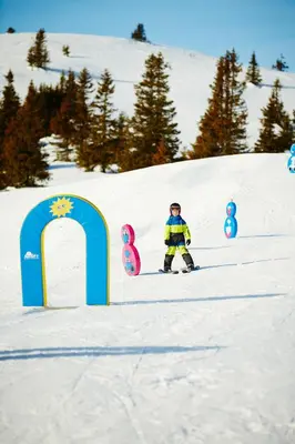 a person on a snowboard in the snow next to a sign at Storefjell Resort - Panorama apartments in Gol