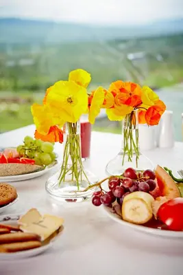 a table with three vases filled with flowers and fruit at Storefjell Resort - Panorama apartments in Gol