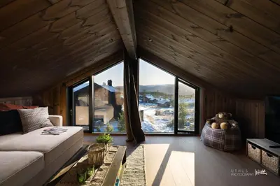a living room with a couch and a large window at Ny og moderne hytte med sauna, jacuzzi og eget spillrom med biljard og dart Gratis elbillading og strøm inkludert i prisen in Flå