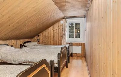 a room with three beds and a window at Awesome Home In Svingvoll With Sauna in Svingvoll
