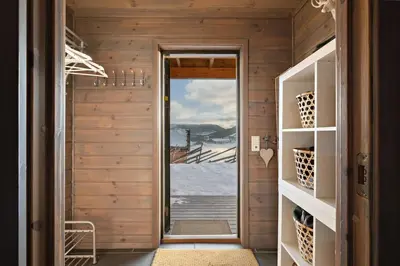a hallway with a door to a room with a view at Spacious cabin with a fabulous view and a sauna in Skulestadmo