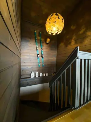 a staircase in a house with a chandelier at Spacious cabin with a fabulous view and a sauna in Skulestadmo