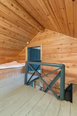 a room with a wooden ceiling with a bed in it at Charming cabin retreat by the coast in Midsund in Midsund