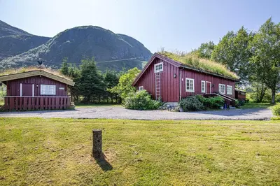 two red barns with a grass roof on a field at Charming cabin retreat by the coast in Midsund in Midsund