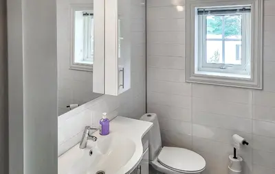 a white bathroom with a sink and a toilet at Nice Home In Vinje With House Sea View in Trovatn