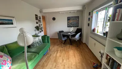 a living room with a green couch and a table at Rustic Apartment in Bakklandet in Trondheim