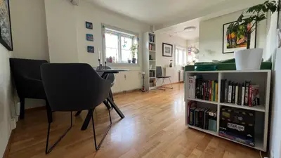 a living room with a table and chairs and a book shelf at Rustic Apartment in Bakklandet in Trondheim