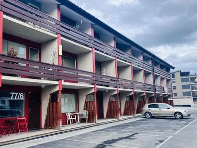 a car parked in a parking lot in front of a building at Sentralt beliggende studioleilighet in Gol