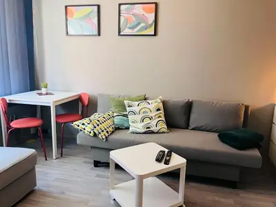 a living room with a couch and a table at Sentralt beliggende studioleilighet in Gol