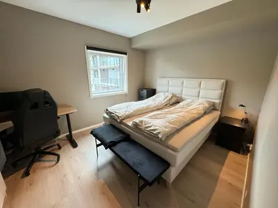 a bedroom with a bed and a desk and a window at Luxury Apartment in Bergen, 10min from City Centre in Bergen