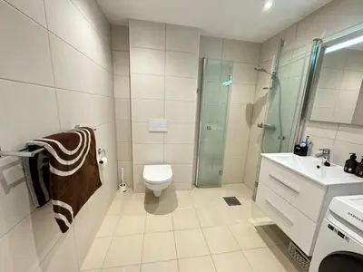 a bathroom with a shower and a toilet and a sink at Luxury Apartment in Bergen, 10min from City Centre in Bergen