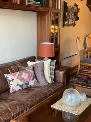 a living room with a brown couch and a table at Toppleilighet Dr Holms in Geilo