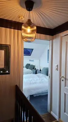 a bedroom with a bed and a chandelier at Toppleilighet Dr Holms in Geilo