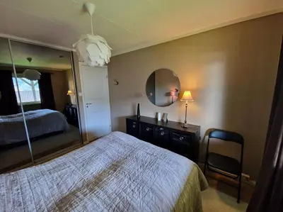 a bedroom with a bed and a large mirror at Hessahuset in Ålesund