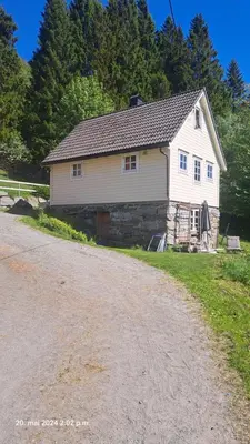 a white house on the side of a dirt road at Kårhus på småbruk in Lia