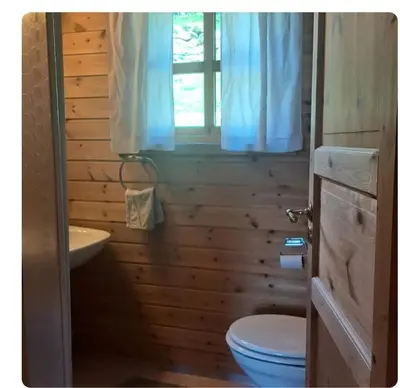 a bathroom with a toilet and a sink and a window at Kårhus på småbruk in Lia