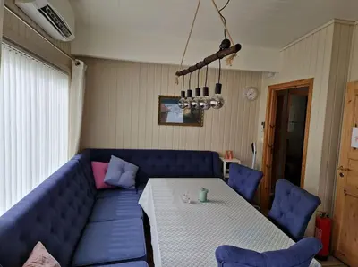 a living room with a blue couch and a table at Feriehus ved fjorden i Solvorn in Luster