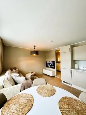 a living room with two tables and a couch at Leilighet i Bergens vakreste gate - Nydelig utsikt over innseilingen til Bergen! in Bergen