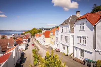 a street in a town with white houses at Leilighet i Bergens vakreste gate - Nydelig utsikt over innseilingen til Bergen! in Bergen