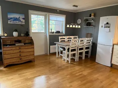a kitchen with a table and a white refrigerator at Cozy apartement near Besseggen with a nice outdoor area! in Randsverk
