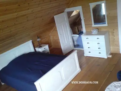 a bedroom with a bed and a dresser and a mirror at Dønhaug Gjestegard in Uskedalen