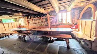 a room with a table and benches in a building at Dønhaug Gjestegard in Uskedalen