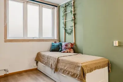 a small bedroom with a bed with a window at Dinbnb Apartments I Explore Bergen! I 650m To Bryggen I Easy Check-in in Bergen