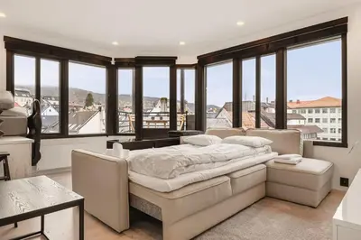 a bedroom with a bed and large windows at Dinbnb Apartments I Penthouse 250m From City Center I Privat Balcony in Bergen